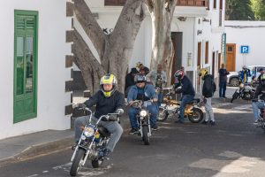 groepje brommerrijders die op de klassieke brommers net het dorp verlaat